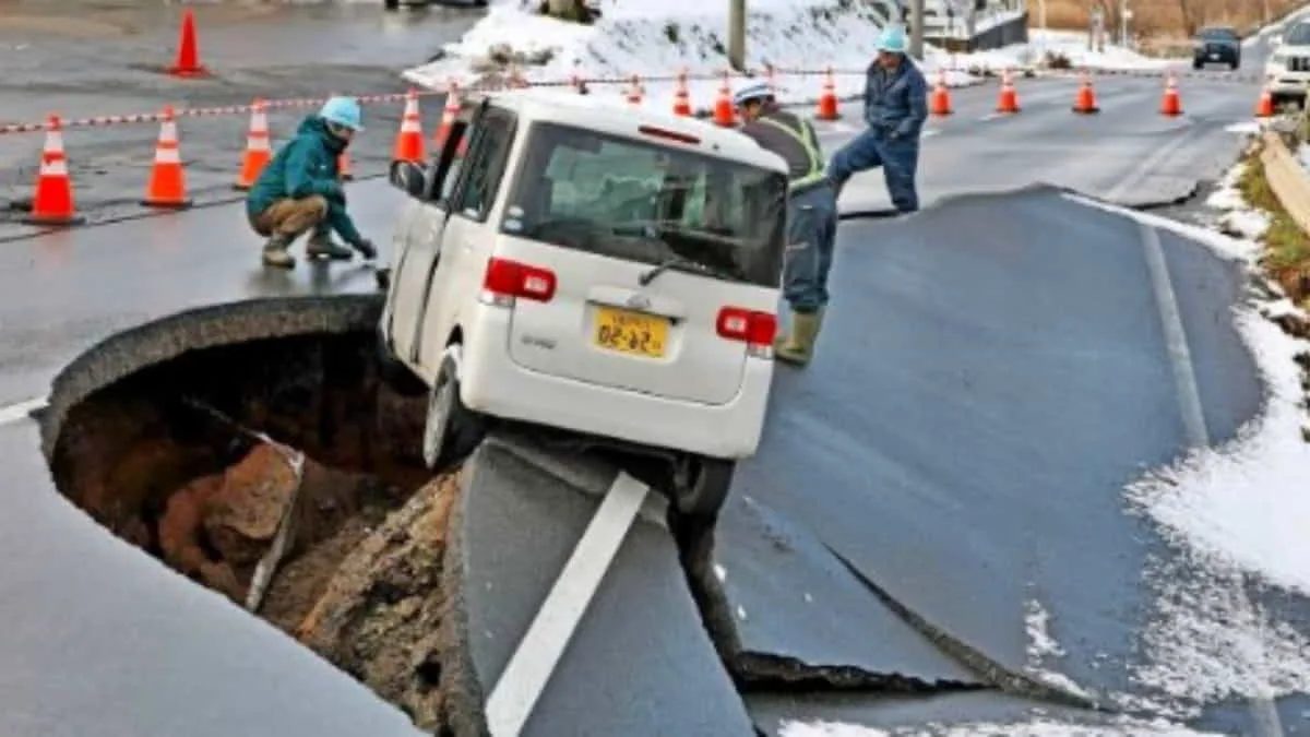 Petugas berupaya mengevakuasi mobil di jalan yang amblas akibat guncangan gempa di Jepang. Pemerintah Jepang mempercepat langkah mitigasi bencana setelah gempa M7,5 mengguncang negara tersebut. Foto: net/