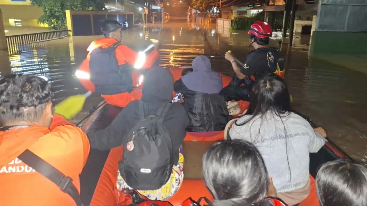 Petugas BPBD Kabupaten Bandung mengevakuasi warga terdampak banjir di Kelurahan Andir, Kabupaten Bandung, Jawa Barat, menggunakan perahu karet. Berdasarkan data BPBD, bencana hidrometeorologi itu menyergap 13 Kecamatan di Kabupaten Bandung. Foto: trustjabar/
