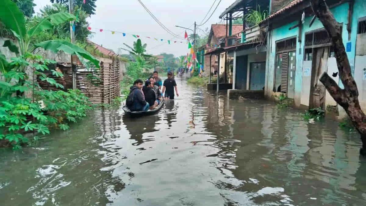 Warga di Dayeuhkolot Kabupaten Bandung, Jawa Barat, menggunakan perahu kayu menerobos genangan banjir yang menerjang kawasan pemukiman mereka. Tidak hanya di Daeyuhkolot, banjir juga menerjang kawasan Kecamatan Cileunyi. Foto: ist/